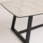 Detaliu generat al blatului cu venatură, muchiei subțiri și structurii metalice geometrice