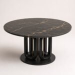 Masă de dining rotundă Orbit cu blat închis venat și bază sculpturală, perspectivă alternativă generată
