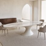 Masă de dining Nevia cu blat oval marmorat și soclu fluid, ambient de dining generat