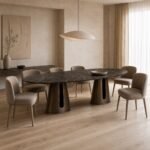 Masă de dining Loggia cu blat oval din piatră și baze decupate, ambient de dining generat