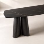 Detaliu generat al blatului mineral negru segmentat și perechii de picioare conice din lemn