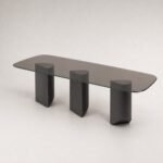 Masă de dining Sylvan cu blat din sticlă fumurie și trei baze din lemn sculptat, perspectivă alternativă generată