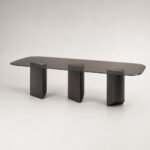 Masă de dining Sylvan cu blat din sticlă fumurie și trei baze din lemn sculptat, imagine principală generată