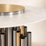 Detaliu generat al blatului mineral perlat, platoului auriu și cilindrilor metalici