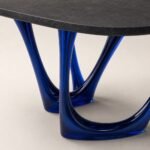 Detaliu generat al blatului antracit și soclurilor arcuite albastru-cobalt