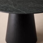 Detaliu generat al blatului mineral verde-negru și soclului conic din lemn