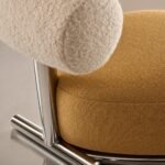 Detaliu generat al spătarului bouclé, tapițeriei camel și structurii cromate