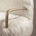 Detaliu generat al blănii artificiale ivoire și brațului metalic champagne