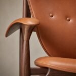 Detaliu generat al pielii cognac, nasturilor, cadrului din nuc și cotierei sculptate